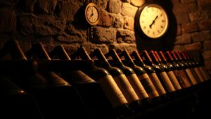 Bouteilles de vin rouge couchées dans une cave avec thermomètre à 16-18 degrés